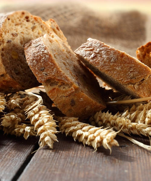 Pane tagliato a fette e spighe di grano