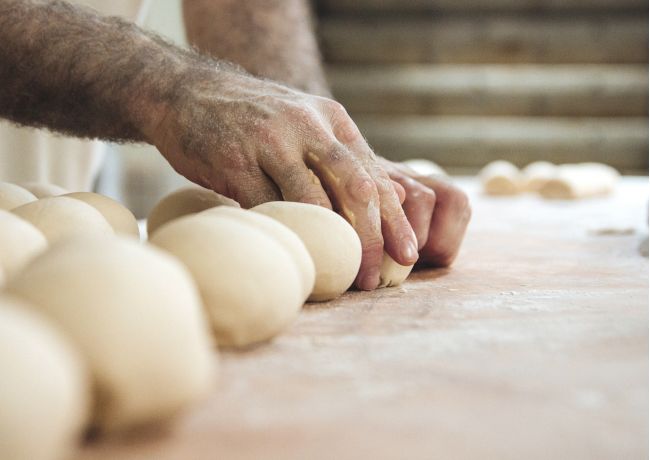 Artigiano che impasta il pane a mano